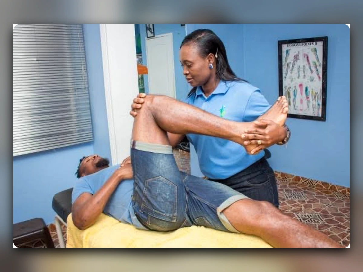 Physiotherapist guiding assisted leg stretching during rehabilitation.