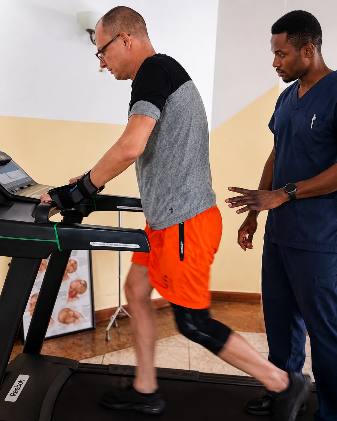 Physiotherapist supporting treadmill rehabilitation.